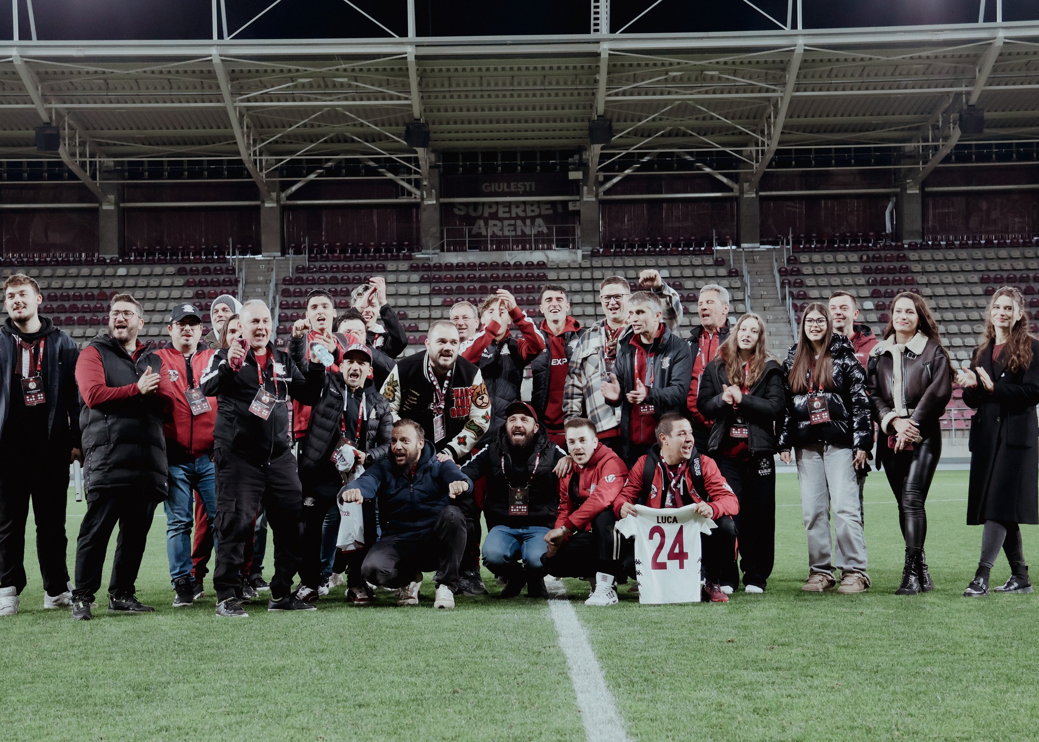 Grup de voluntari FC Rapid în echipament oficial oferind asistență pe stadion în timpul unui meci din 2025