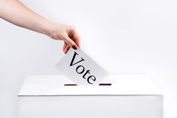 Woman puts ballot in voting box 821267